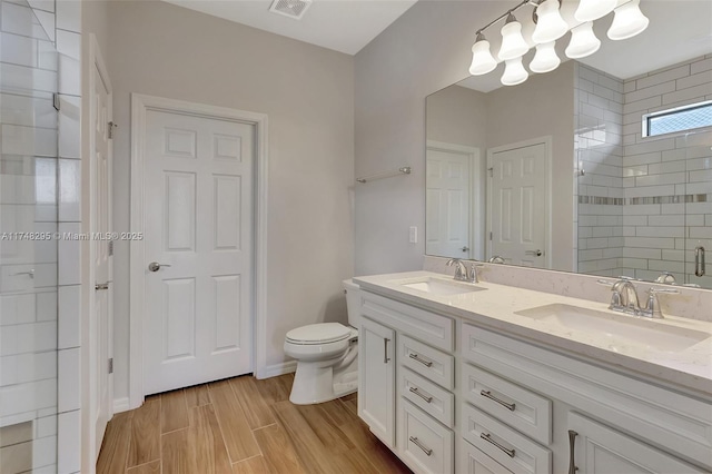 bathroom with double vanity, a stall shower, visible vents, and a sink