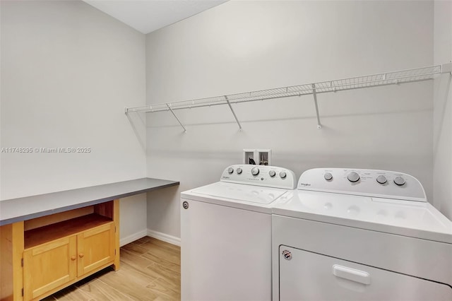 laundry area featuring light wood-style floors, washing machine and dryer, laundry area, and baseboards