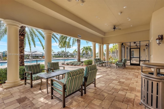 view of patio with ceiling fan and a community pool