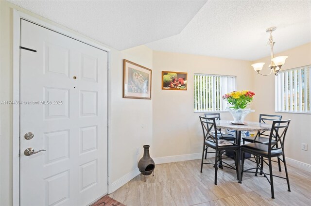 801 Sw 141 101O, Pembroke Pines, FL 33027 - dining room featuring a textured ceiling, baseboards, an inviting chandelier, and a wealth of natural light