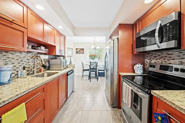 801 Sw 141 101O, Pembroke Pines, FL 33027 - kitchen with decorative backsplash, appliances with stainless steel finishes, a sink, light stone counters, and a chandelier