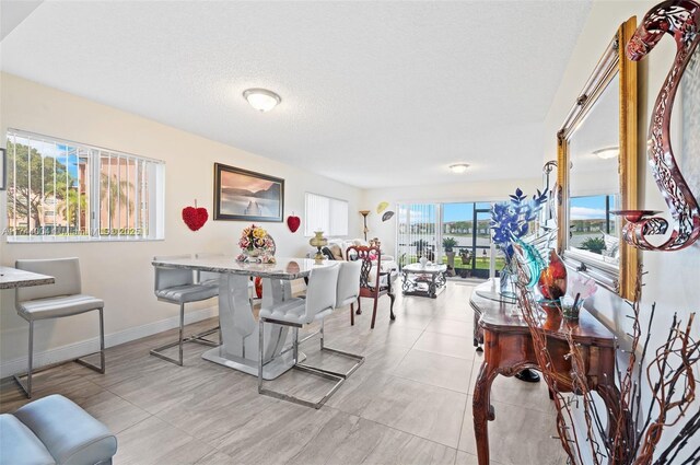 801 Sw 141 101O, Pembroke Pines, FL 33027 - dining room featuring a textured ceiling and baseboards