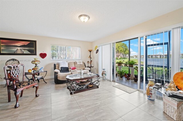 801 Sw 141 101O, Pembroke Pines, FL 33027 - living area with a healthy amount of sunlight, baseboards, and a textured ceiling