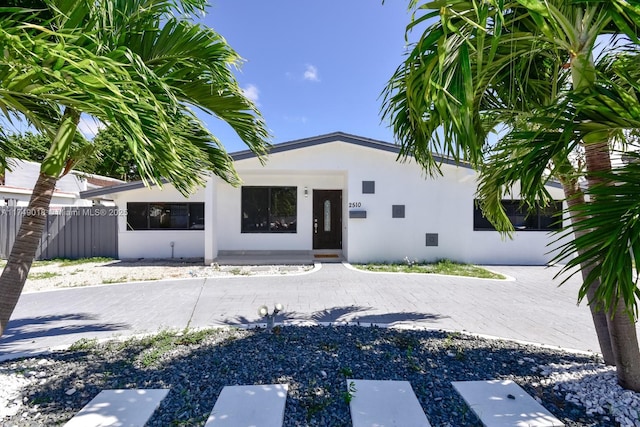 doorway to property with fence and stucco siding