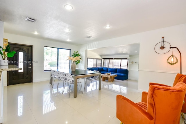 dining space with light tile patterned floors, plenty of natural light, visible vents, and baseboards