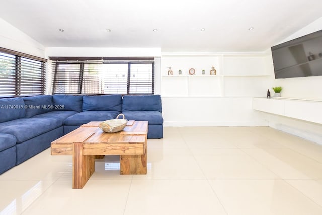 living area with vaulted ceiling and light tile patterned flooring