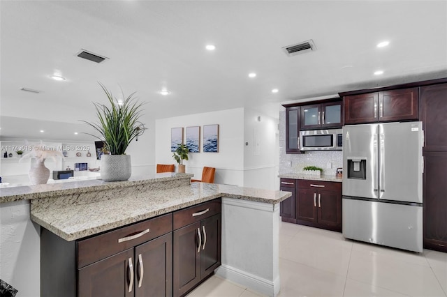 2510 NE 215th St, Miami, FL 33180 - kitchen featuring appliances with stainless steel finishes, light stone counters, visible vents, and recessed lighting