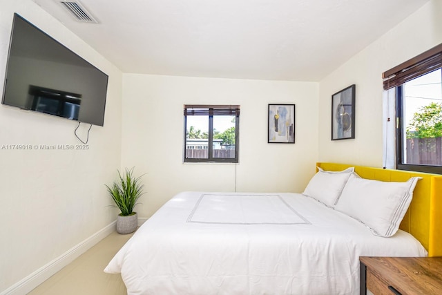 bedroom featuring multiple windows, visible vents, and baseboards