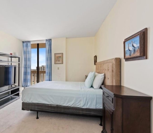 bedroom with access to outside, a wall of windows, and light colored carpet