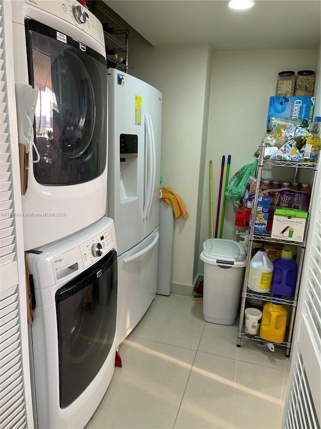 laundry room featuring stacked washer / dryer, laundry area, and light tile patterned floors