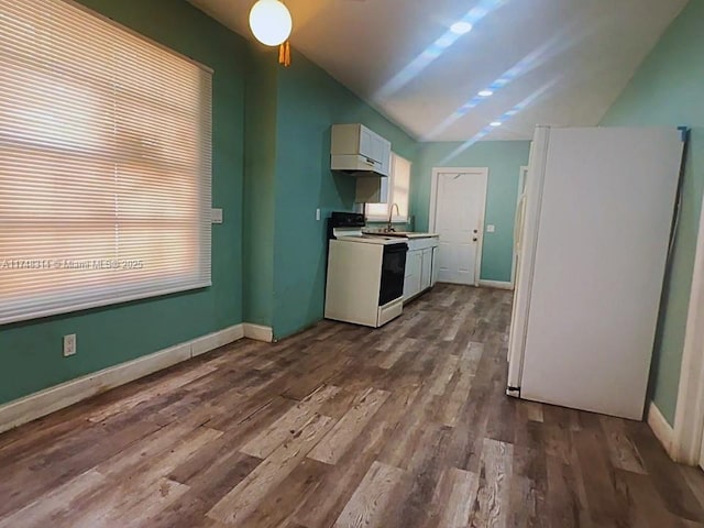 kitchen with white appliances, wood finished floors, a sink, baseboards, and white cabinets