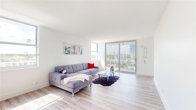 living area with light wood-type flooring, expansive windows, and baseboards