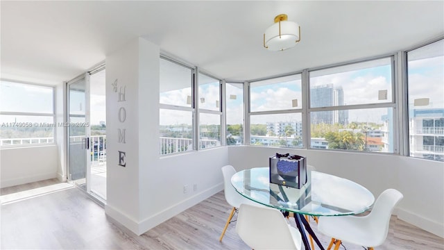 dining room featuring a view of city, baseboards, and wood finished floors