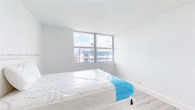 bedroom featuring light wood-type flooring and baseboards