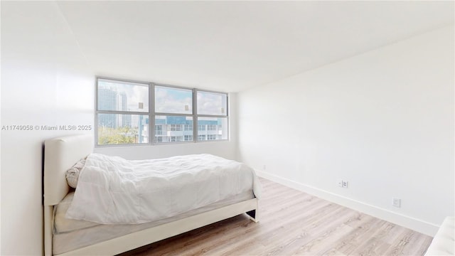 bedroom featuring baseboards and wood finished floors