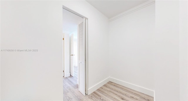 hallway with light wood-style flooring and baseboards