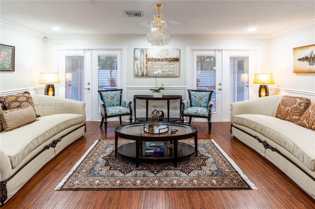 living room with visible vents, dark wood-type flooring, crown molding, and french doors