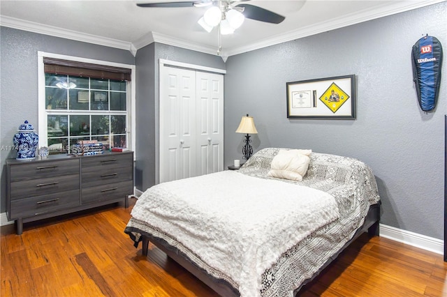 bedroom featuring ornamental molding, dark wood-type flooring, a closet, and baseboards