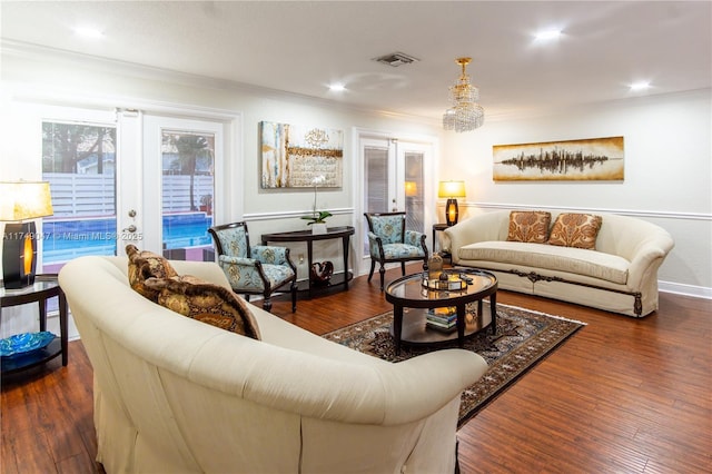 living area with dark wood-type flooring, french doors, visible vents, and ornamental molding