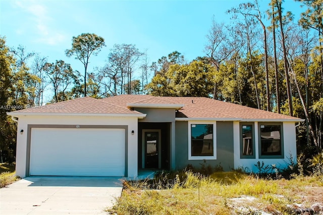 single story home featuring a garage, driveway, a shingled roof, and stucco siding