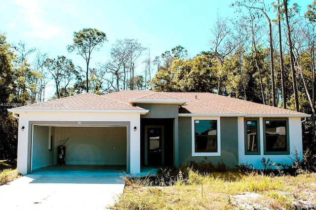 ranch-style home with a garage, concrete driveway, a shingled roof, and stucco siding