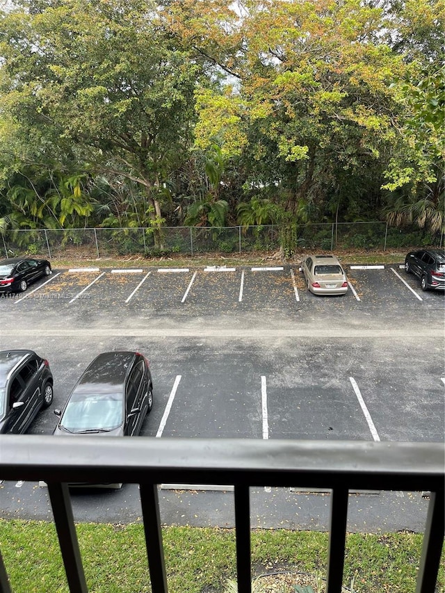 uncovered parking lot featuring fence