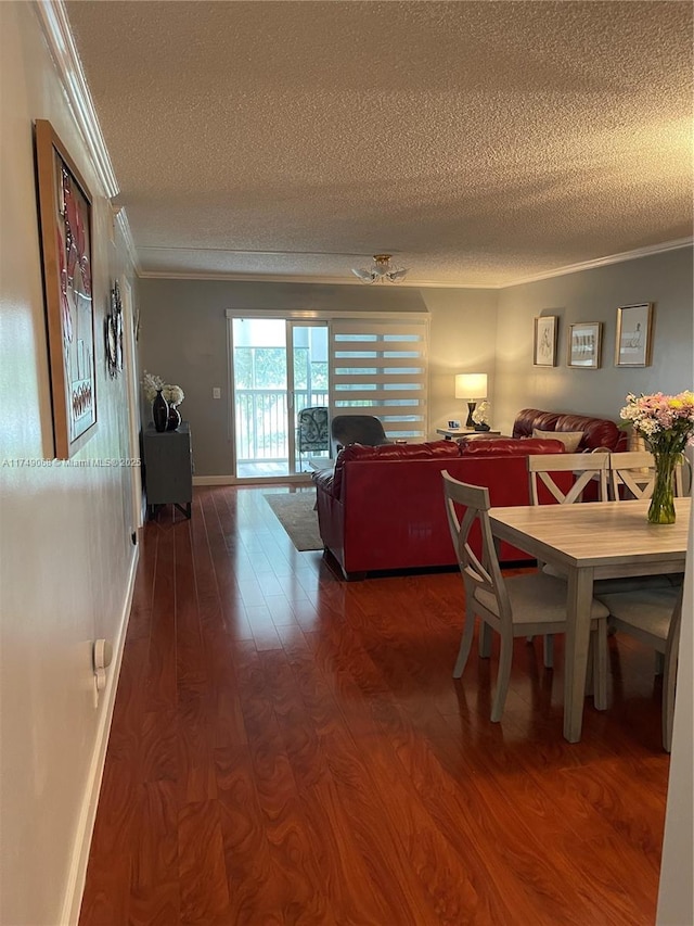 dining area featuring a textured ceiling, wood finished floors, and crown molding