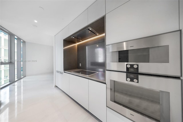 kitchen with double oven, black electric stovetop, white cabinets, dark countertops, and modern cabinets