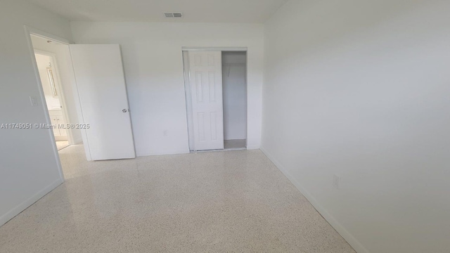 11715 SW 183rd St, Miami, FL 33177 - empty room featuring speckled floor and baseboards