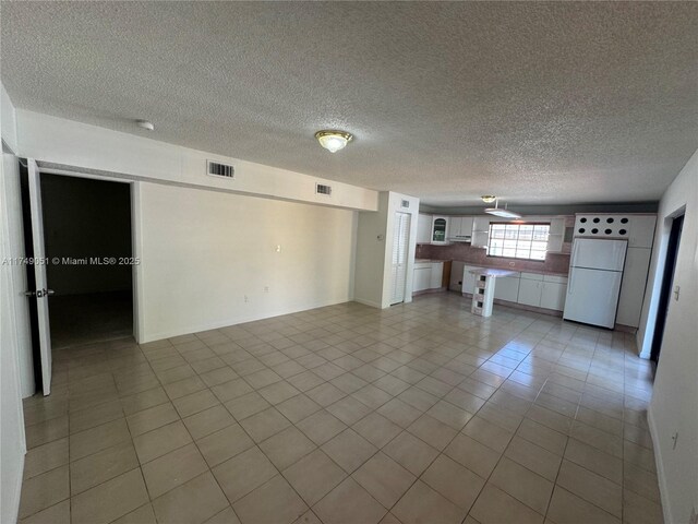 11715 SW 183rd St, Miami, FL 33177 - unfurnished living room with a textured ceiling and light tile patterned floors