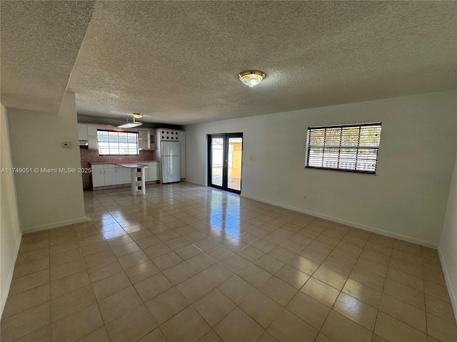 11715 SW 183rd St, Miami, FL 33177 - unfurnished room featuring a textured ceiling, light tile patterned floors, baseboards, and plenty of natural light