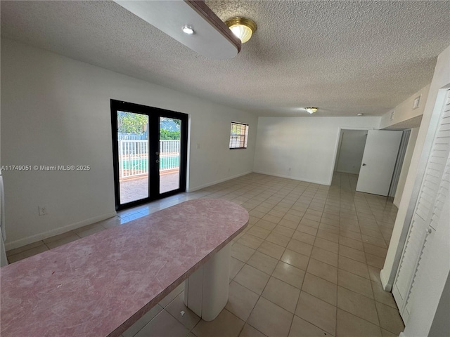 11715 SW 183rd St, Miami, FL 33177 - empty room with light tile patterned floors, french doors, a textured ceiling, and baseboards