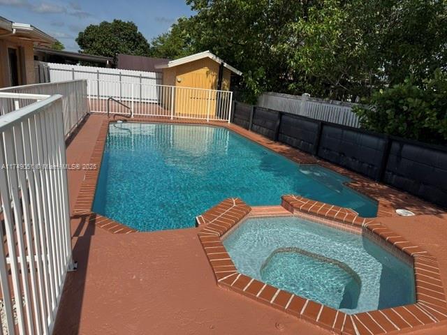 11715 SW 183rd St, Miami, FL 33177 - view of swimming pool featuring a fenced backyard and a pool with connected hot tub