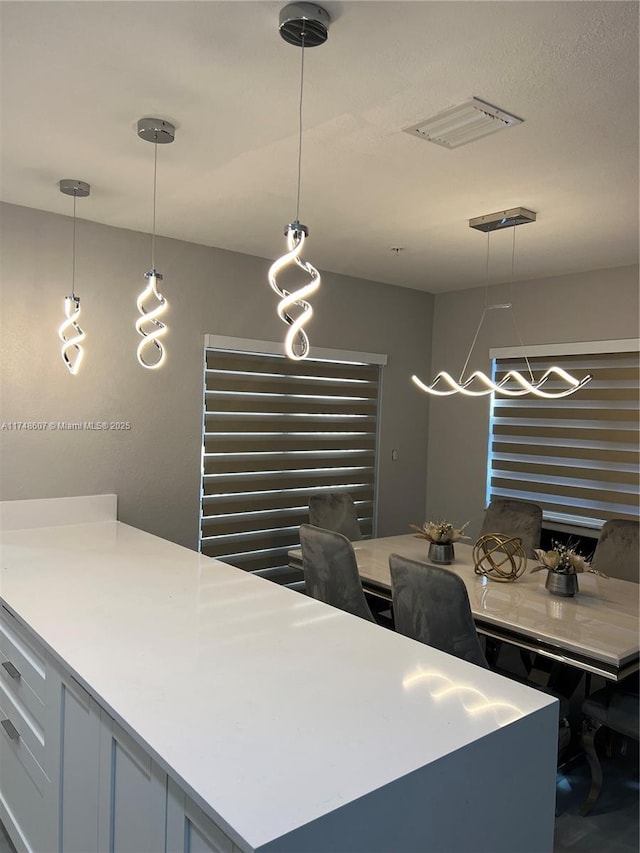 kitchen featuring hanging light fixtures, light countertops, and visible vents