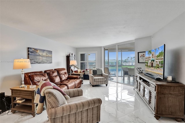 living room featuring marble finish floor, a textured ceiling, and expansive windows