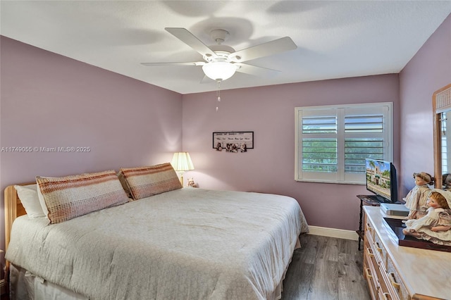 bedroom featuring dark wood-type flooring, baseboards, and ceiling fan