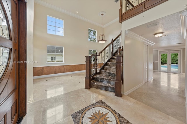 staircase featuring a towering ceiling, baseboards, marble finish floor, french doors, and crown molding