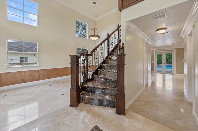 stairs featuring a healthy amount of sunlight, visible vents, crown molding, and french doors