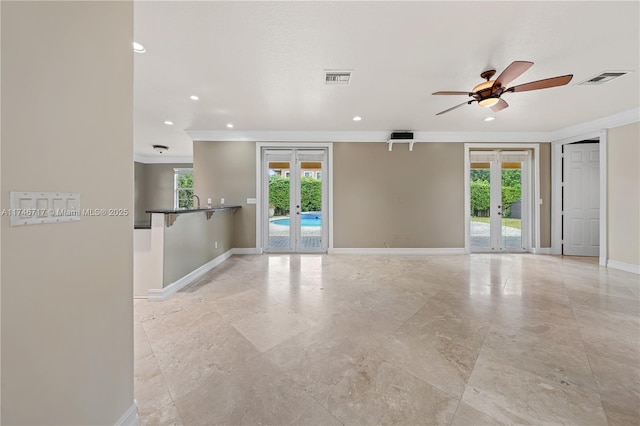 empty room with french doors, plenty of natural light, and baseboards