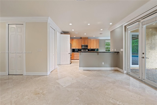 kitchen featuring baseboards, dark countertops, stainless steel appliances, a kitchen bar, and recessed lighting