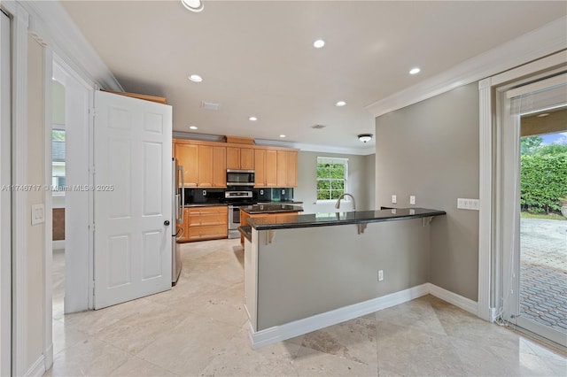 kitchen with a peninsula, appliances with stainless steel finishes, dark countertops, and a wealth of natural light