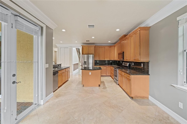 kitchen with a center island, backsplash, appliances with stainless steel finishes, a sink, and baseboards