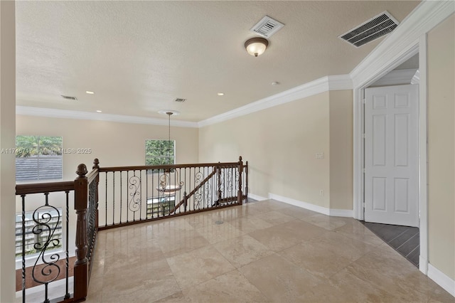 hallway with an upstairs landing, visible vents, and crown molding