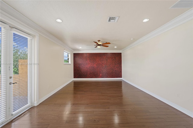 empty room with visible vents, dark wood-style flooring, and ornamental molding