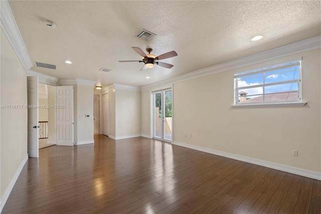 spare room featuring dark wood-style flooring, visible vents, crown molding, and a textured ceiling