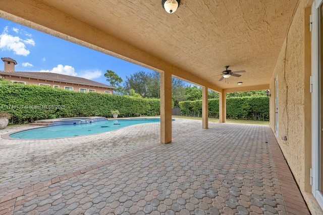 view of swimming pool with a ceiling fan, a patio area, a fenced backyard, and a pool with connected hot tub