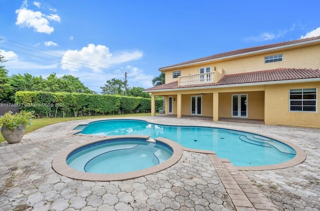 view of swimming pool with a patio area, a pool with connected hot tub, and a ceiling fan