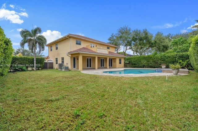 back of property featuring a yard, a patio area, fence, and stucco siding