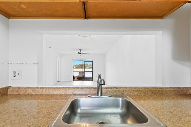 kitchen with a ceiling fan, light countertops, and a sink