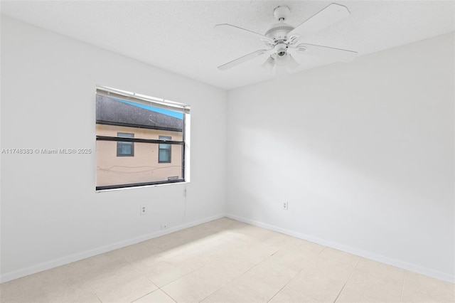 spare room with a textured ceiling, a ceiling fan, and baseboards